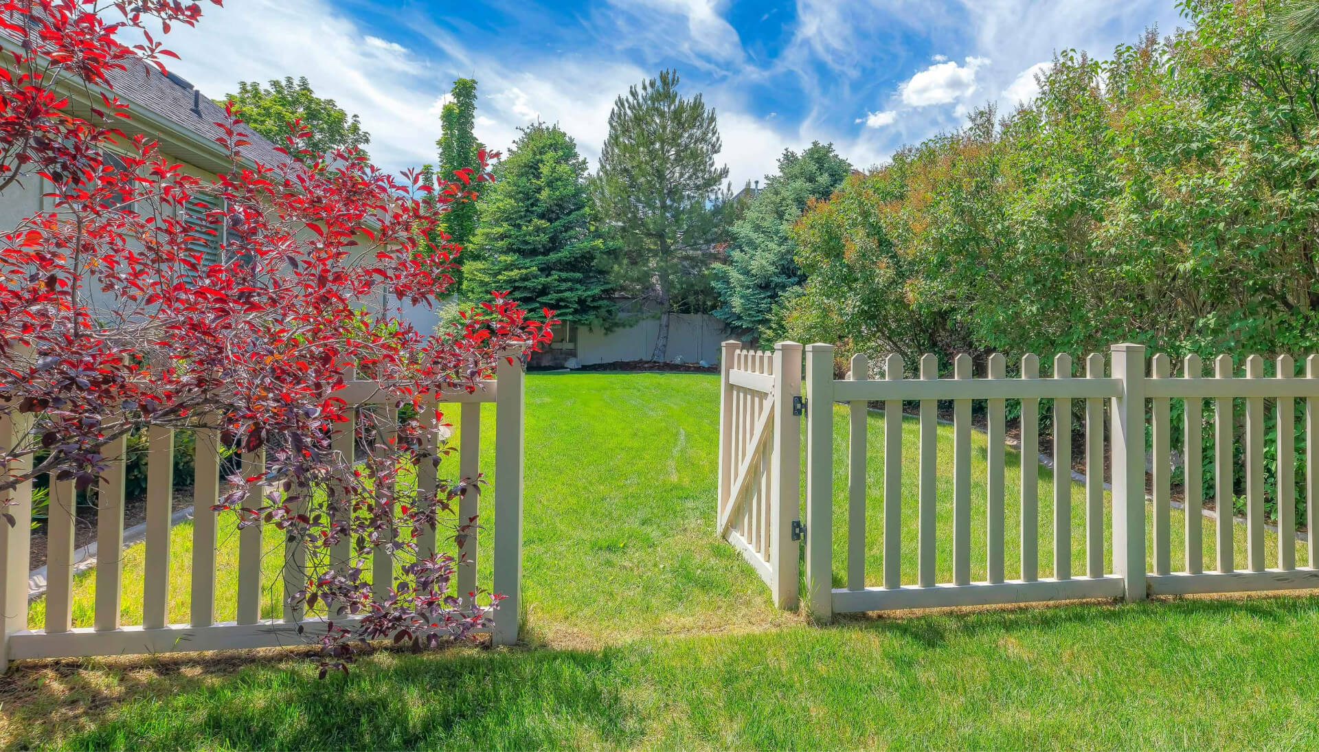A functional fence gate providing access to a well-maintained backyard, surrounded by a wooden fence in Grand Rapids